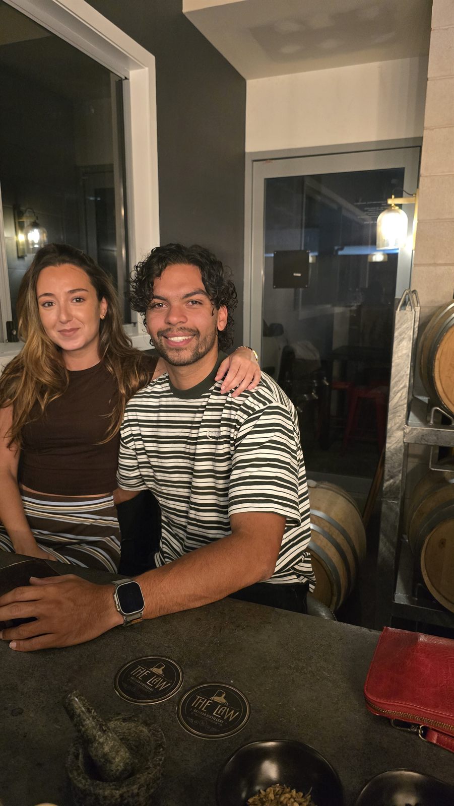 Chloe and Pablo behind the bar at The Law Artisan Distillery cellar door